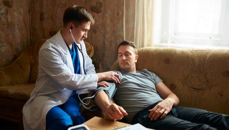 Врач-нарколог на дом измеряет давление пациента