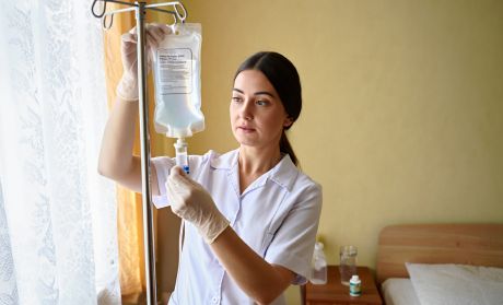 Врач ставит капельницу для детоксикации дома у пациента