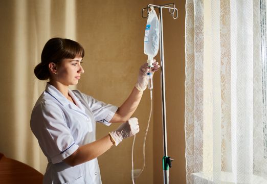 Медсестра устанваливает капельницу на дому